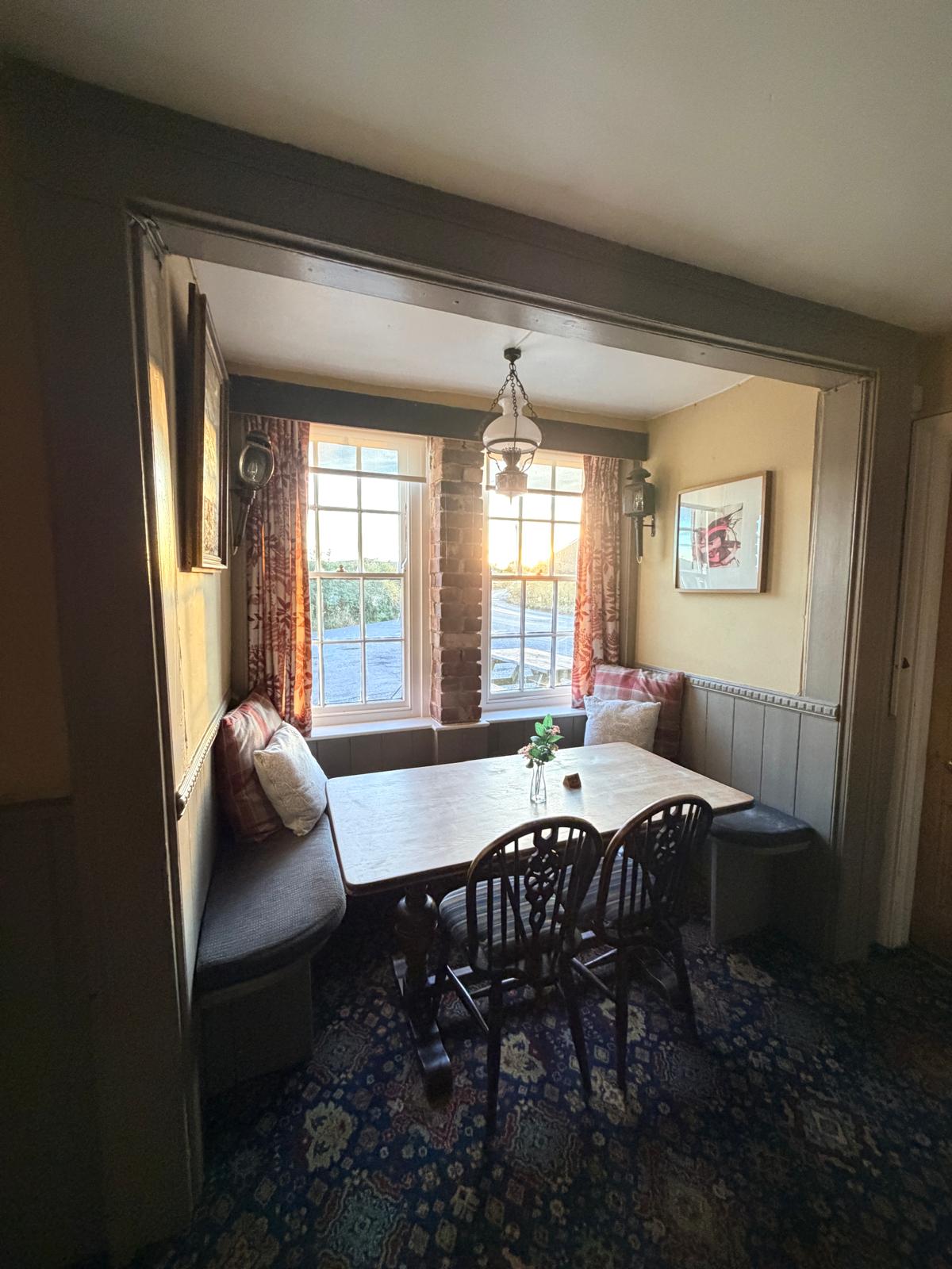 A window snug with cushioned settle seating overlooking the lane